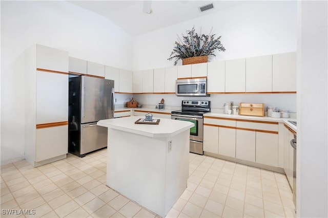 2141 Tama Cir Unit 202, Naples, FL 34112 - kitchen featuring appliances with stainless steel finishes, light countertops, a kitchen island, a towering ceiling, and light tile patterned flooring