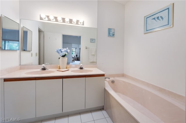 bathroom with tile patterned flooring, a washtub, and vanity