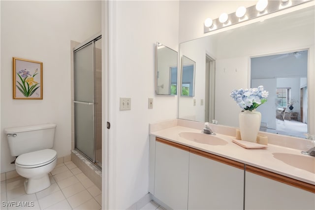 bathroom with toilet, vanity, tile patterned floors, and a shower with door