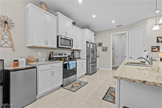 kitchen with white cabinets, light stone counters, light tile patterned floors, sink, and stainless steel appliances