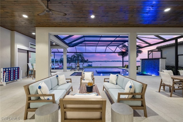 patio terrace at dusk featuring an outdoor hangout area, glass enclosure, and ceiling fan