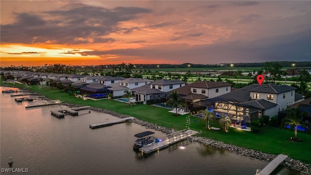 aerial view at dusk featuring a water view