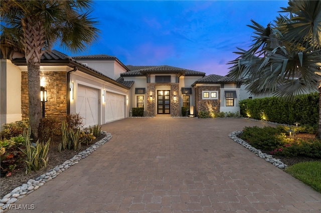 mediterranean / spanish home with french doors and a garage