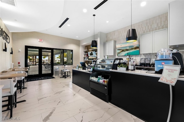 kitchen with white cabinets, french doors, and decorative light fixtures