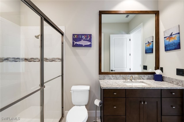 bathroom featuring a shower with door, vanity, and toilet