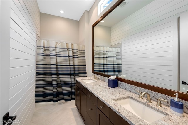 bathroom featuring parquet flooring, vanity, and wooden walls