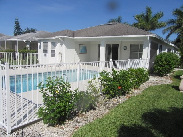 rear view of property with a fenced in pool