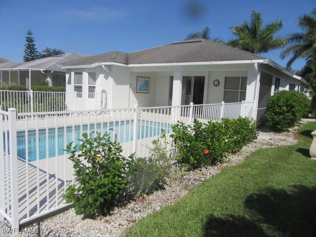 592 Crossfield Cir, Naples, FL 34104 - back of property featuring stucco siding and a shingled roof