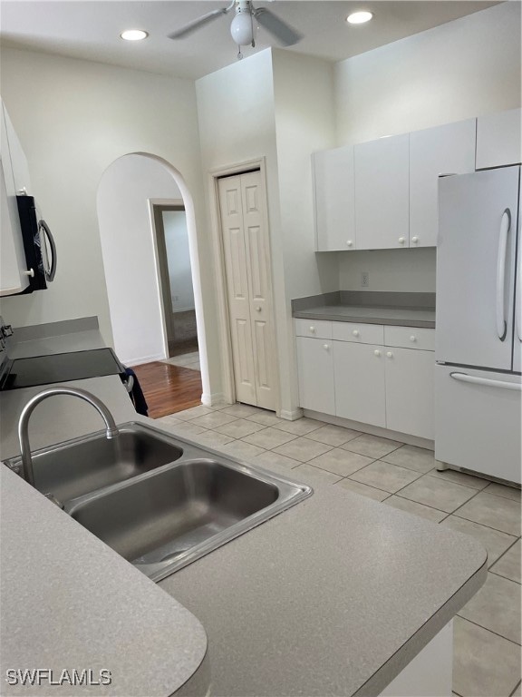 kitchen featuring light tile patterned floors, ceiling fan, white cabinetry, and white fridge