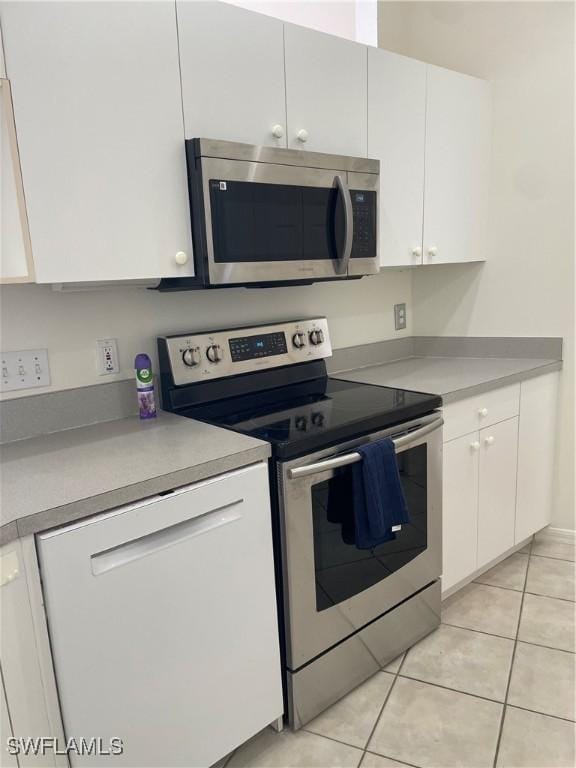 592 Crossfield Cir, Naples, FL 34104 - kitchen with appliances with stainless steel finishes, white cabinets, light tile patterned floors, and light countertops