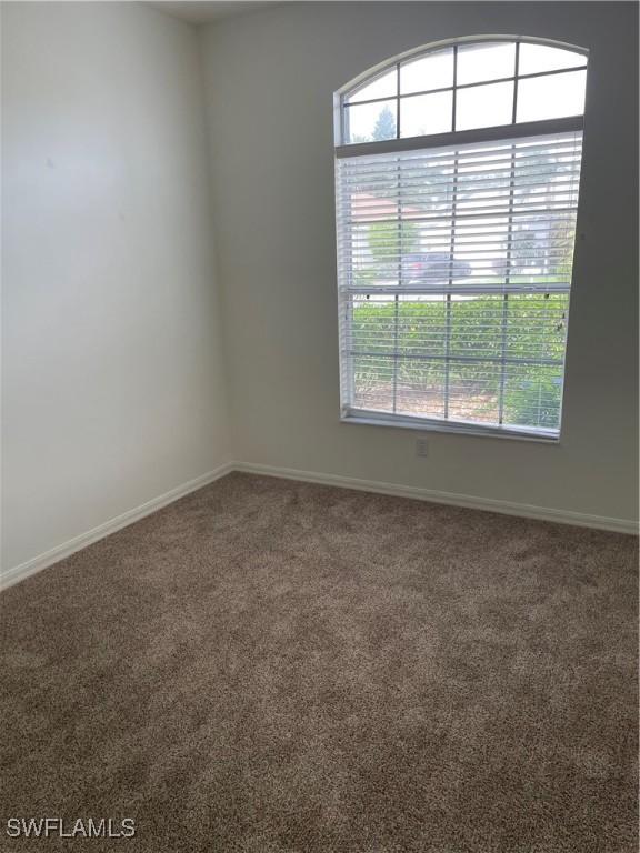 592 Crossfield Cir, Naples, FL 34104 - carpeted empty room featuring healthy amount of natural light and baseboards