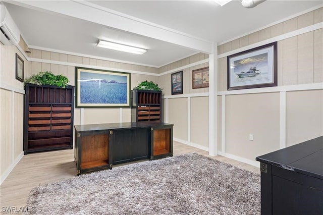 unfurnished office featuring a wall mounted AC, light hardwood / wood-style flooring, and ornamental molding