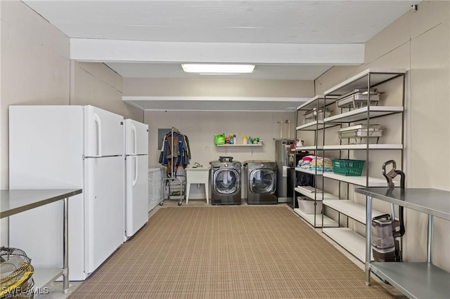 laundry area with water heater, sink, and separate washer and dryer