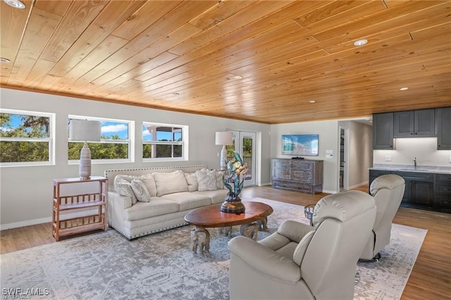 living room with sink, crown molding, wooden ceiling, and light hardwood / wood-style flooring