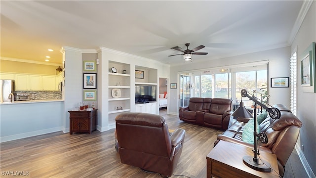 living room with ornamental molding, wood-type flooring, and ceiling fan