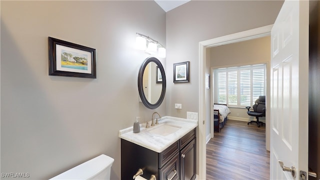 bathroom featuring vanity, hardwood / wood-style flooring, and toilet