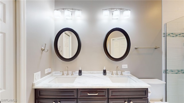 bathroom with toilet, vanity, and an enclosed shower