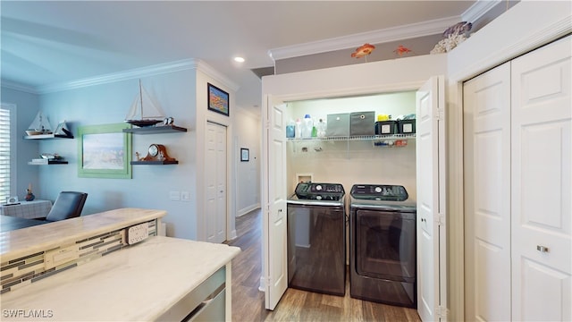 kitchen featuring ornamental molding, light wood-type flooring, and washing machine and dryer