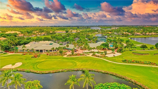 aerial view at dusk featuring a water view