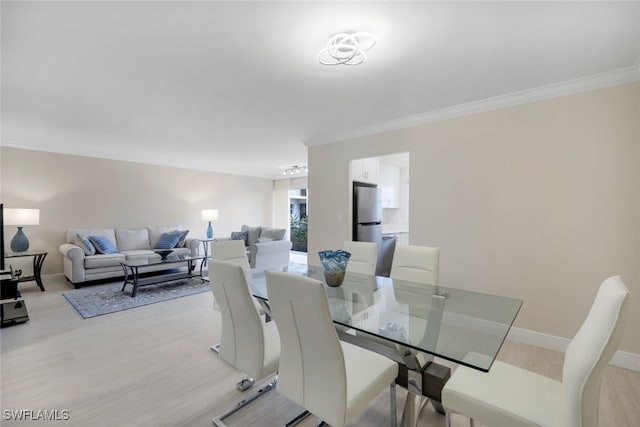 dining room with light hardwood / wood-style flooring and ornamental molding