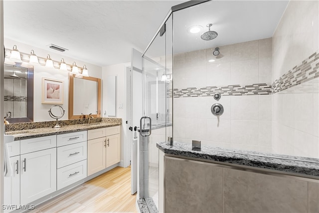 bathroom featuring an enclosed shower, vanity, and hardwood / wood-style flooring