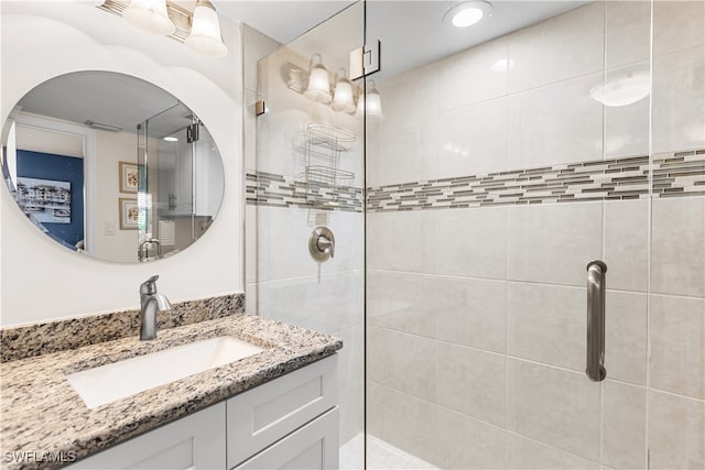 bathroom with vanity and a shower with door