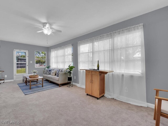 living room featuring light colored carpet and ceiling fan