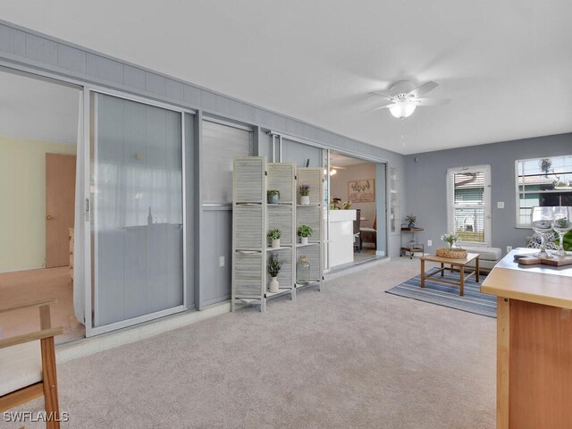 carpeted living room with ceiling fan