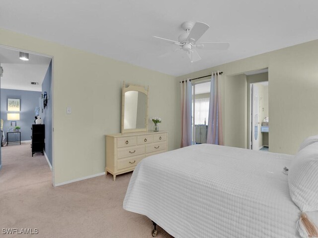 carpeted bedroom featuring ceiling fan and ensuite bath