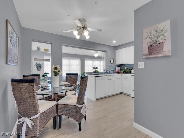 dining space featuring sink, ceiling fan, and light hardwood / wood-style flooring