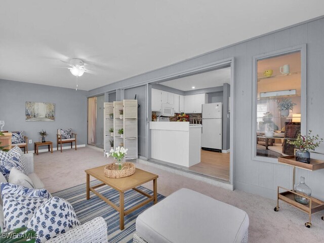 carpeted living room with ceiling fan