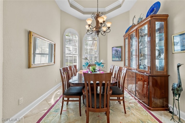 tiled dining room with a raised ceiling, crown molding, and a notable chandelier