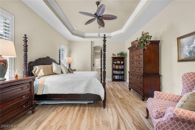 bedroom with a raised ceiling, ceiling fan, light hardwood / wood-style flooring, and ornamental molding