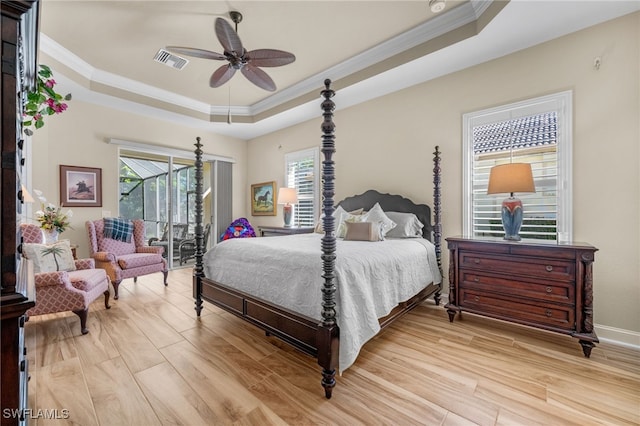 bedroom featuring light hardwood / wood-style flooring, a raised ceiling, ceiling fan, and ornamental molding