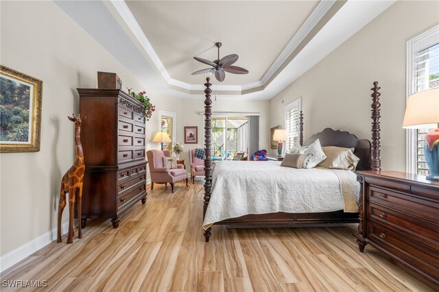 bedroom featuring a raised ceiling, ceiling fan, crown molding, and light wood-type flooring