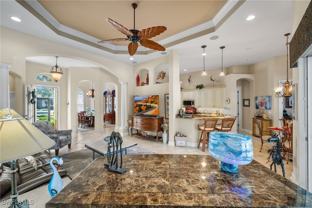 kitchen with crown molding, hanging light fixtures, and a tray ceiling