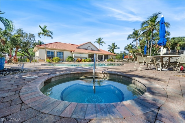 view of pool with a patio and a hot tub