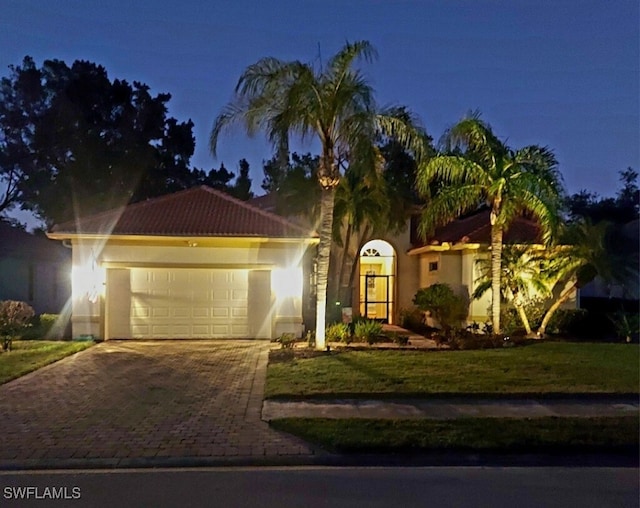 mediterranean / spanish house with a yard and a garage