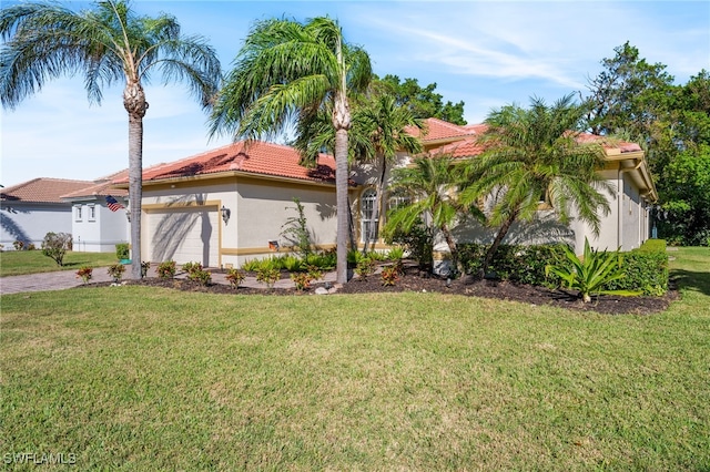 mediterranean / spanish home featuring a front yard and a garage