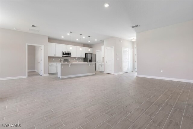 unfurnished living room featuring sink and light wood-type flooring