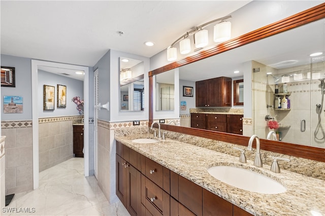 bathroom featuring walk in shower, vanity, and tile walls