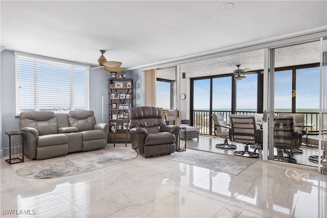 living room with expansive windows, a healthy amount of sunlight, and a water view