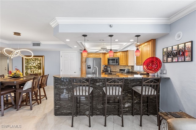 kitchen with stainless steel appliances, ornamental molding, a breakfast bar area, ceiling fan, and pendant lighting