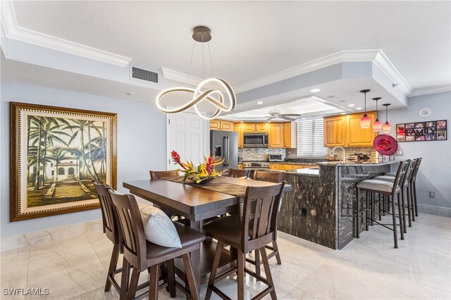 dining area with a raised ceiling, ceiling fan, and crown molding