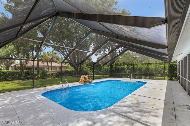 view of pool with a patio, a yard, and glass enclosure