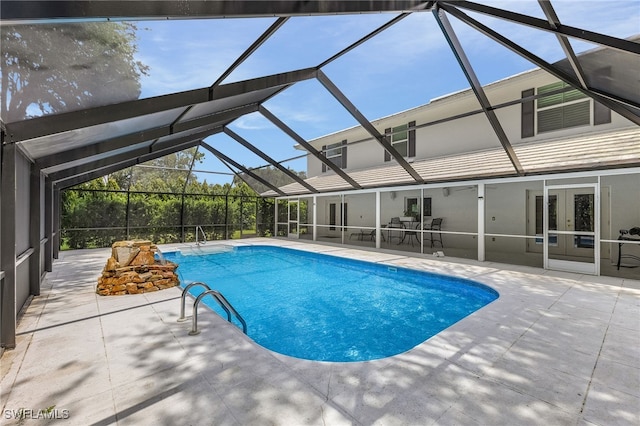 view of pool featuring glass enclosure and a patio area