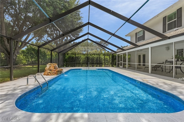 view of pool with a patio area, a lanai, ceiling fan, and pool water feature