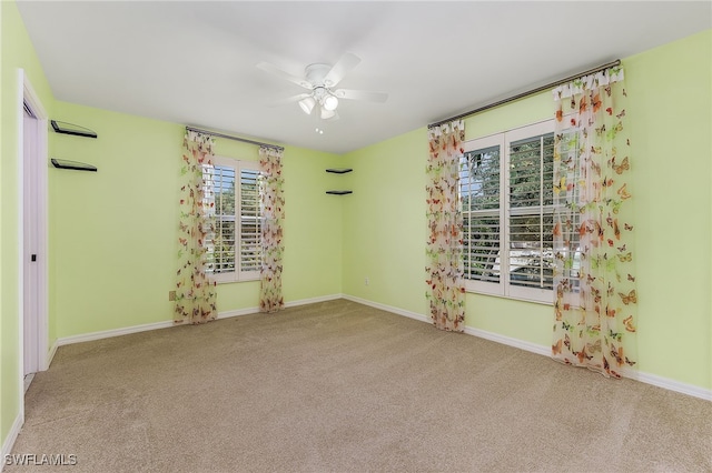 empty room featuring ceiling fan and light carpet