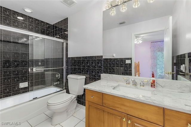 full bathroom with tile patterned floors, combined bath / shower with glass door, tile walls, and toilet