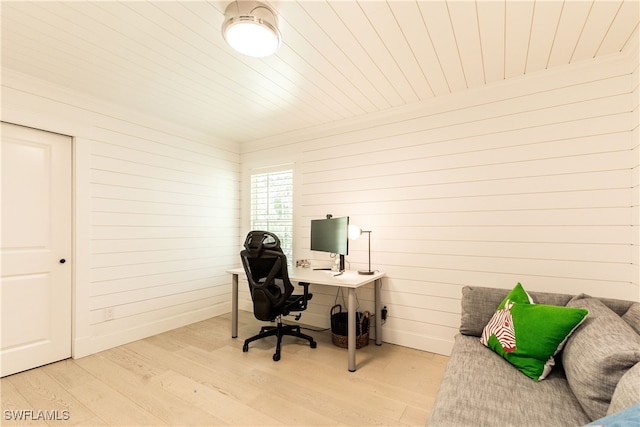 office with light wood-type flooring and wooden walls